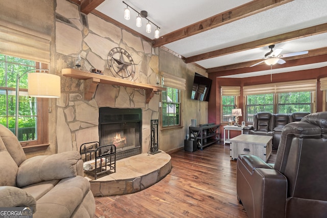 1627 Leguin Mill Rd, Locust Grove, GA 30248 - living room with beam ceiling, ceiling fan, hardwood / wood-style floors, a stone fireplace, and baseboards