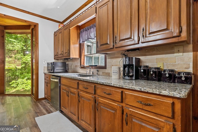 kitchen with stainless steel appliances, ornamental molding, a sink, tasteful backsplash, and brown cabinetry