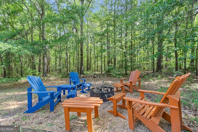 view of yard with a fire pit and a forest view