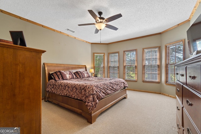 bedroom featuring ornamental molding, a textured ceiling, light carpet, ceiling fan, and baseboards