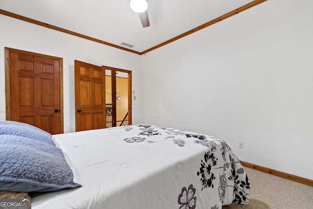 carpeted bedroom featuring ornamental molding, baseboards, and ceiling fan