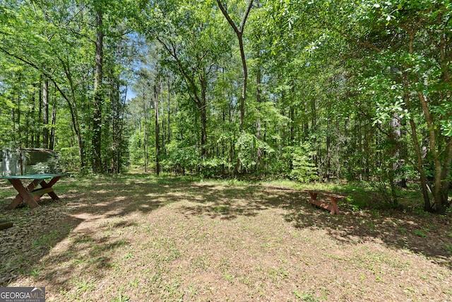 view of yard featuring a forest view