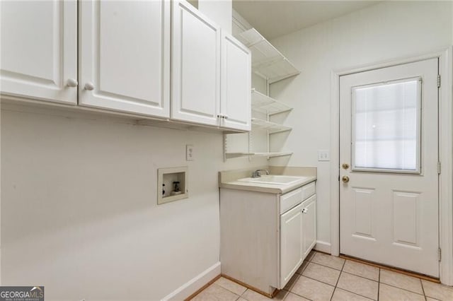 clothes washing area featuring washer hookup, light tile patterned flooring, cabinet space, and baseboards