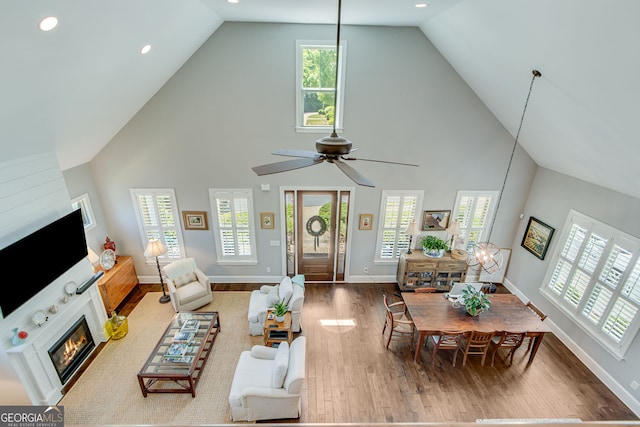 131 Village Dr, Clarkesville, GA 30523 - living area with high vaulted ceiling, wood finished floors, a glass covered fireplace, ceiling fan, and baseboards