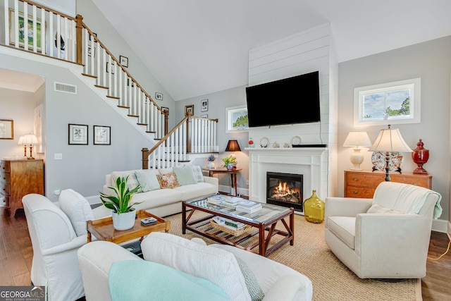 131 Village Dr, Clarkesville, GA 30523 - living room with wood finished floors, a glass covered fireplace, stairs, and baseboards