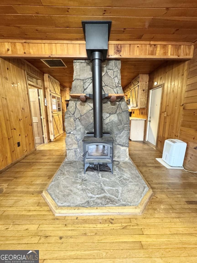 456 Pickelsimer Rd, Blairsville, GA 30512 - detailed view of wood finished floors, wooden walls, wood ceiling, a wood stove, and baseboards
