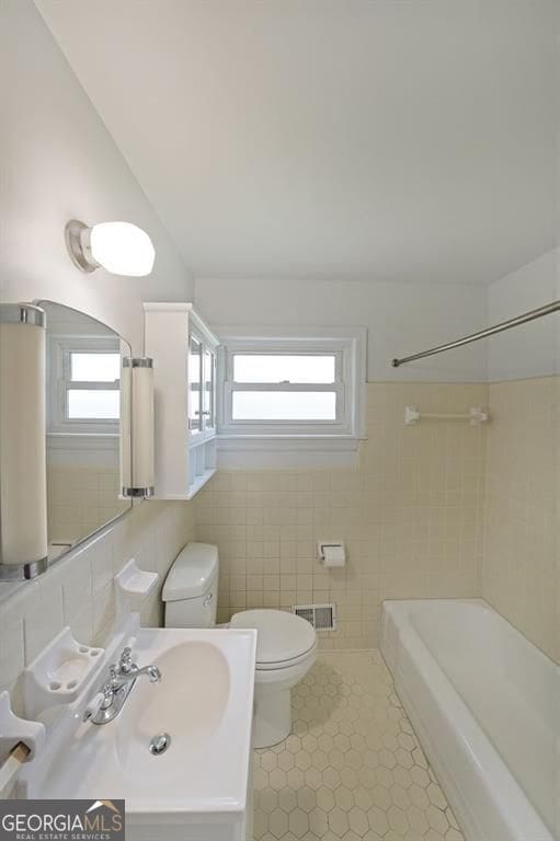 629 Birchwood Rd, Marietta, GA 30060 - full bath featuring toilet, tile patterned flooring, tile walls, vanity, and shower / tub combination