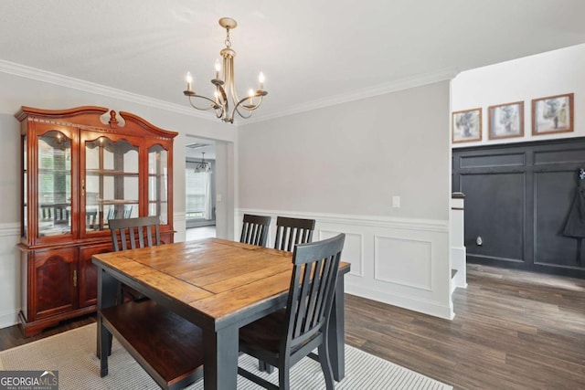 309 Nashview Trl, Allenhurst, GA 31301 - dining space with a decorative wall, a chandelier, crown molding, dark wood-type flooring, and a wainscoted wall