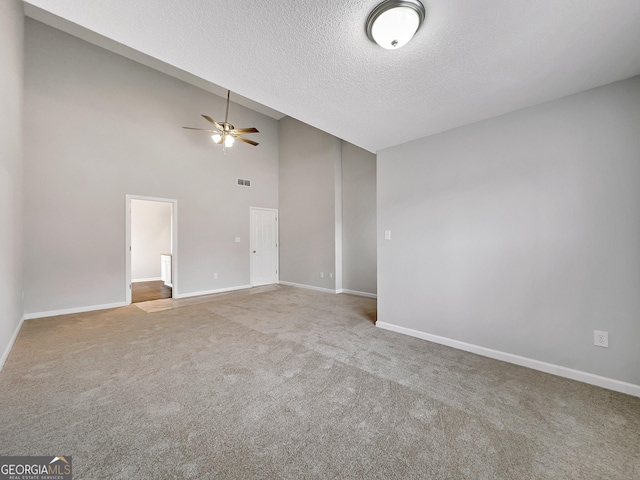 7006 Mahonia Pl, Lithonia, GA 30038 - unfurnished living room with a ceiling fan, a textured ceiling, carpet flooring, baseboards, and high vaulted ceiling