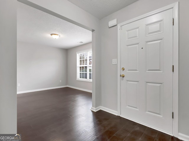 7006 Mahonia Pl, Lithonia, GA 30038 - entrance foyer featuring a textured ceiling, dark wood-style floors, and baseboards