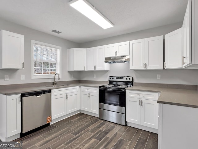 7006 Mahonia Pl, Lithonia, GA 30038 - kitchen featuring appliances with stainless steel finishes, a sink, under cabinet range hood, and dark wood-style flooring