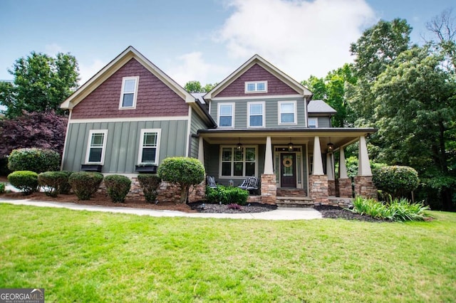 craftsman inspired home with board and batten siding, covered porch, and a front lawn