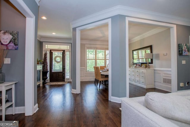 entryway featuring dark wood finished floors, a decorative wall, recessed lighting, a wainscoted wall, and ornamental molding