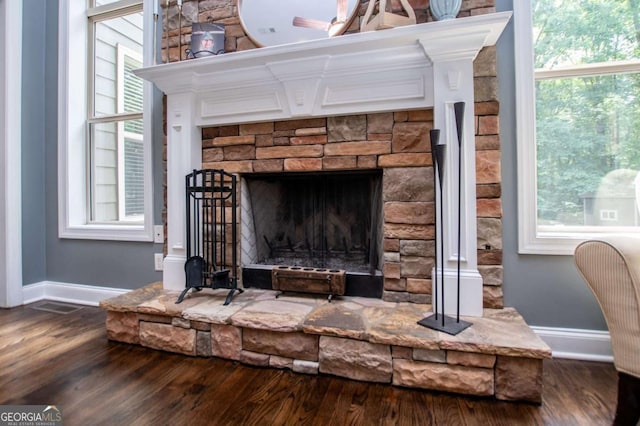 detailed view of wood finished floors, baseboards, and a fireplace