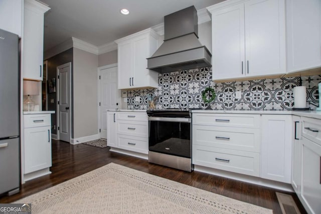 kitchen with custom range hood, appliances with stainless steel finishes, dark wood finished floors, light countertops, and ornamental molding