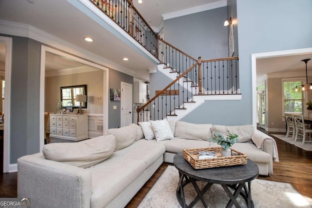 living area featuring ornamental molding, dark wood finished floors, a towering ceiling, healthy amount of natural light, and recessed lighting