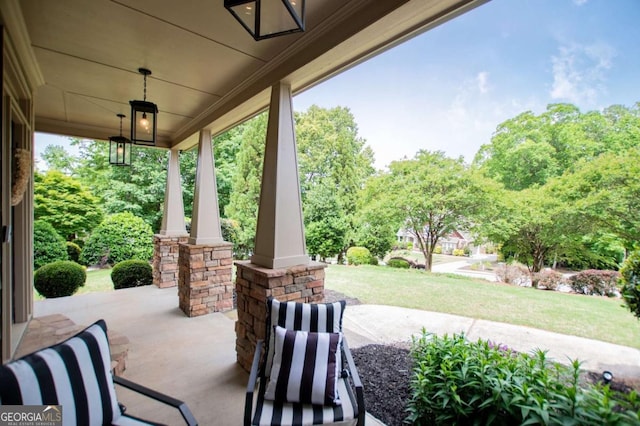 view of patio / terrace featuring a porch and view of wooded area
