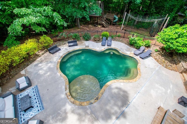 view of swimming pool featuring a patio area and fence