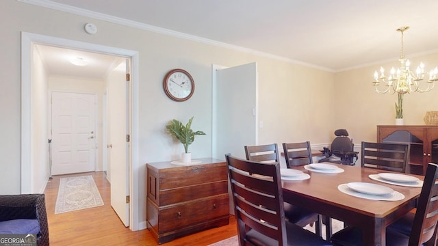dining room with light wood-style flooring, crown molding, and a chandelier