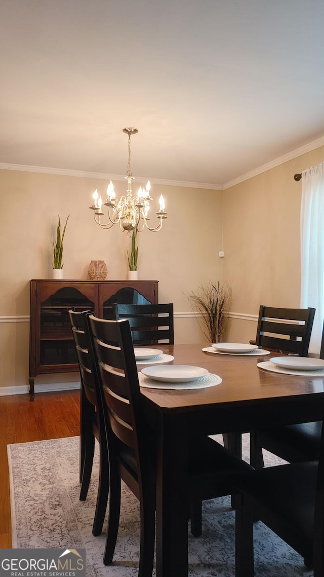 dining space with a chandelier, light wood-style flooring, ornamental molding, and baseboards