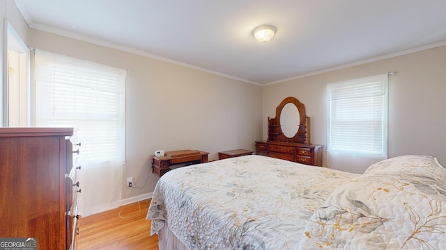 bedroom with crown molding, light wood-style floors, and baseboards