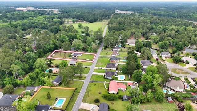 aerial perspective of suburban area featuring property parcel outlined and a heavily wooded area