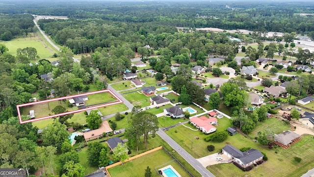 view of property location featuring property parcel outlined, a heavily wooded area, and nearby suburban area