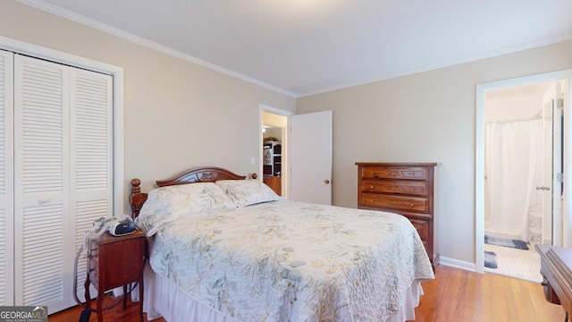 bedroom with wood finished floors, ornamental molding, a closet, baseboards, and connected bathroom