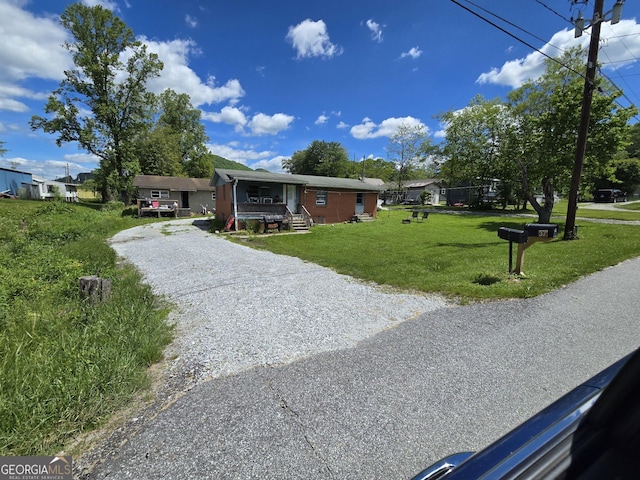 view of front of house featuring gravel driveway and a front lawn