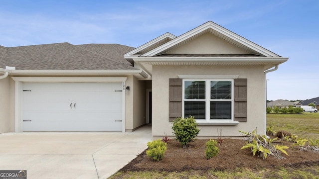 125 The Villas Way, Kingsland, GA 31548 - view of front of house featuring a garage, driveway, stucco siding, and a shingled roof