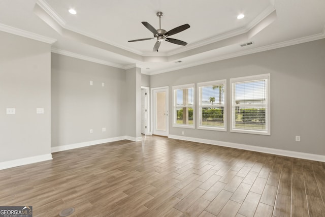 125 The Villas Way, Kingsland, GA 31548 - unfurnished living room featuring a raised ceiling, ceiling fan, wood finished floors, baseboards, and ornamental molding