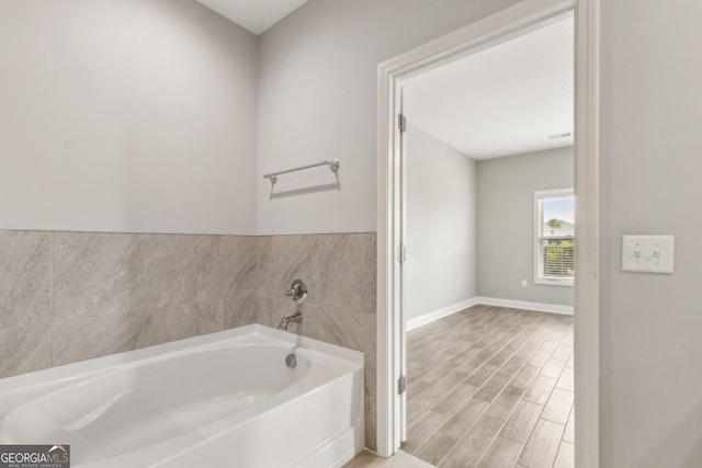 125 The Villas Way, Kingsland, GA 31548 - bathroom with a garden tub, baseboards, and wood finished floors