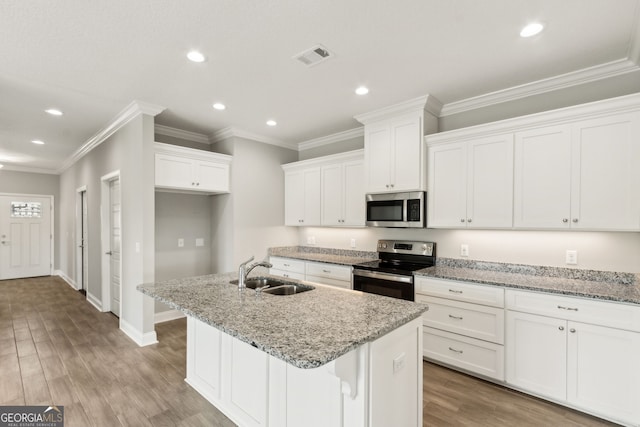 125 The Villas Way, Kingsland, GA 31548 - kitchen with appliances with stainless steel finishes, a sink, recessed lighting, white cabinets, and a kitchen island with sink