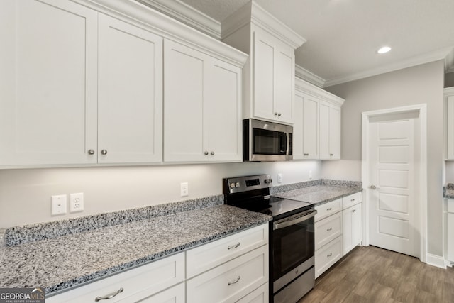 125 The Villas Way, Kingsland, GA 31548 - kitchen featuring appliances with stainless steel finishes, dark wood-style flooring, ornamental molding, white cabinets, and light stone countertops