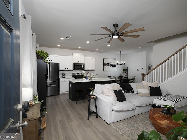 2108 Remy Ct, Kennesaw, GA 30144 - living room featuring ceiling fan, wood finished floors, stairs, recessed lighting, and a chandelier