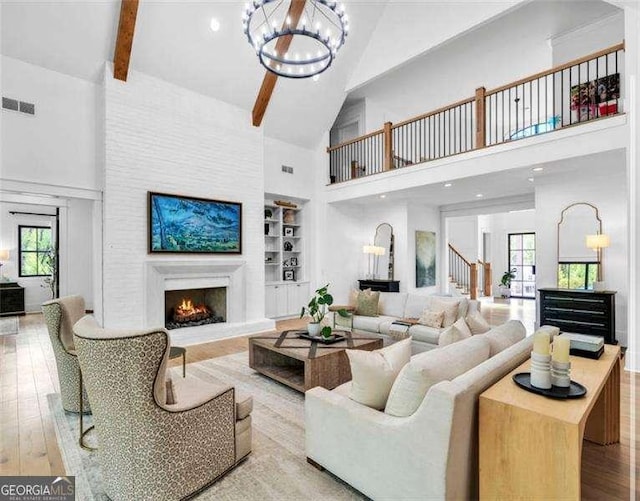 1568 Howell Bridge Rd, Ball Ground, GA 30107 - living room with high vaulted ceiling, a warm lit fireplace, a chandelier, healthy amount of natural light, and built in features