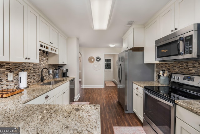900 Bay Laurel Cir, Warner Robins, GA 31088 - kitchen featuring appliances with stainless steel finishes, a sink, baseboards, arched walkways, and dark wood finished floors