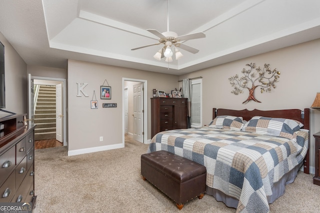 900 Bay Laurel Cir, Warner Robins, GA 31088 - bedroom featuring a tray ceiling, light carpet, baseboards, and a ceiling fan