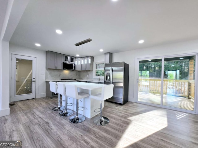 2400 Glenrock Dr, Decatur, GA 30032 - kitchen with appliances with stainless steel finishes, a center island, light wood-style flooring, gray cabinets, and light countertops