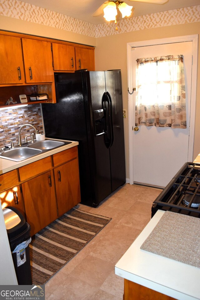 5802 Blueridge Dr, Columbus, GA 31907 - kitchen featuring a sink, black appliances, brown cabinets, backsplash, and light countertops
