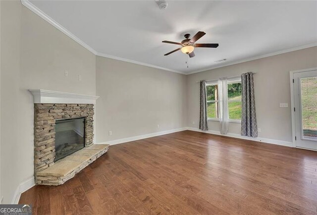 47 Whitley Ct, Dallas, GA 30157 - unfurnished living room featuring a ceiling fan, wood finished floors, baseboards, crown molding, and a stone fireplace