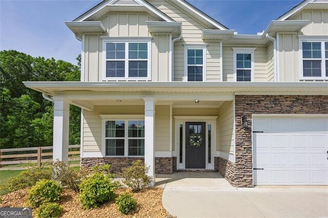47 Whitley Ct, Dallas, GA 30157 - view of front of home with board and batten siding, stone siding, fence, driveway, and an attached garage