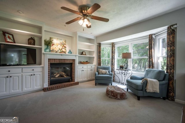 carpeted living area with a fireplace, a textured ceiling, ceiling fan, and built in features