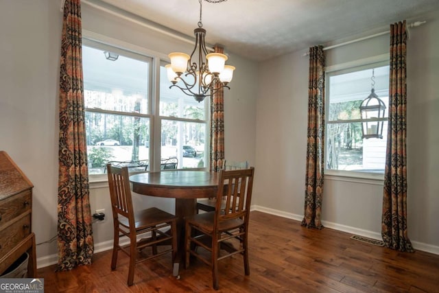 dining area with a chandelier, dark wood-style floors, and baseboards