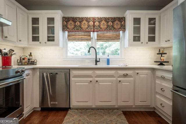 kitchen featuring appliances with stainless steel finishes, a sink, light countertops, and white cabinets