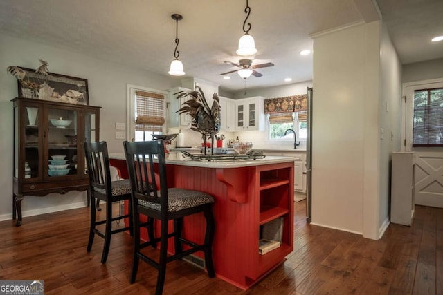 kitchen with open shelves, white cabinets, a ceiling fan, dark wood-type flooring, and a center island