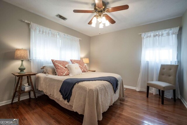 bedroom featuring baseboards, wood finished floors, and a ceiling fan