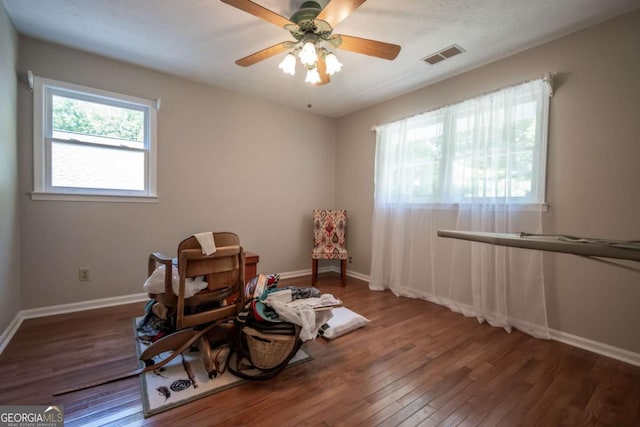 sitting room featuring wood finished floors, baseboards, and a ceiling fan