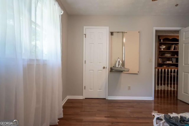 unfurnished bedroom with wood finished floors and baseboards
