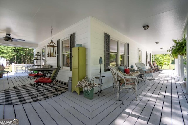 deck with covered porch, outdoor dining space, and a ceiling fan
